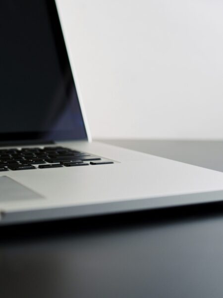 silver laptop computer on black table